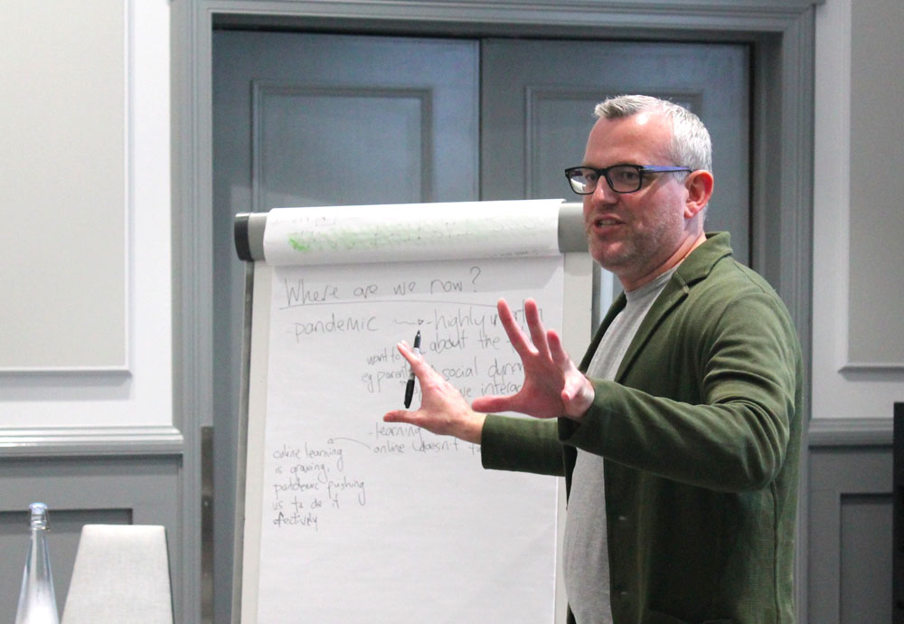 A photo of Dreu Harrison facilitating a group from a flipchart